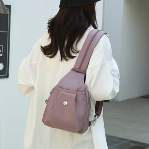 Minimalist light purple oxford fabric mini backpack shown on model in street setting