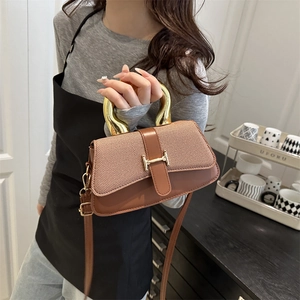 Brown square handbag with gold metal handle and H-lock, worn as a crossbody bag
