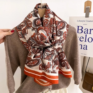 Bohemian paisley silk scarf in vintage orange and brown styled on a cozy brown sweater