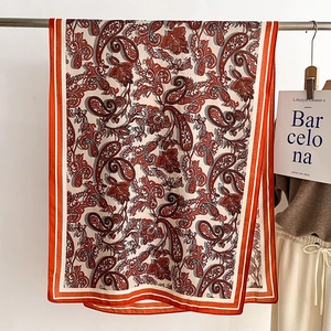 Detail of vintage paisley pattern scarf with silky texture and orange border