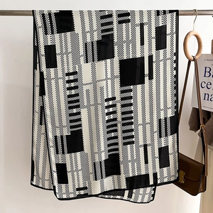 Detail of minimalist black and white geometric silk scarf with checkerboard pattern