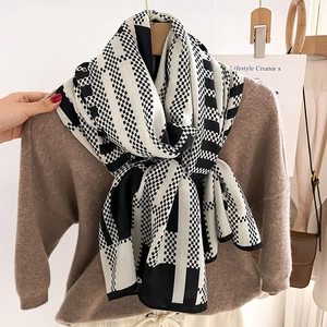 Chic black and white geometric color-block scarf styled over a brown knit sweater