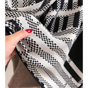 Close-up of soft black and white geometric pattern knit fabric for winter scarves