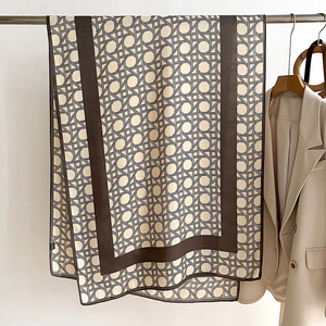 Detail of silk scarf featuring retro geometric weave patterns and dark brown borders