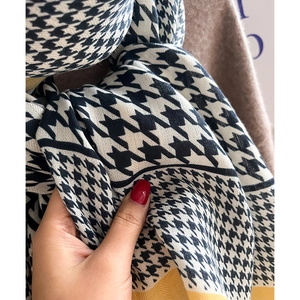 Detailaufnahme des schwarz-weißen Hahnentritt-Schals mit gelbem Rand und weicher Textur