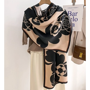 Elegant black and beige camellia print silk scarf draped for a classic luxury look