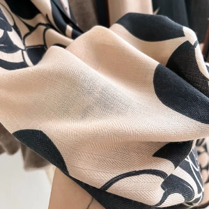 Close-up of premium twill fabric with black camellia floral patterns and soft texture