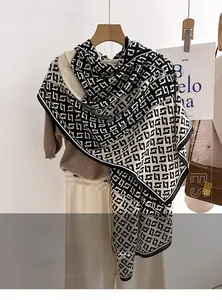 Detail of soft black and white geometric pattern scarf draped on a wooden hanger