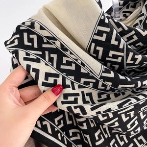 Macro shot of black and beige geometric patterned knit scarf with diagonal texture detail