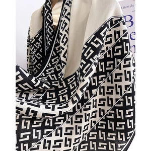 Detailed view of black and white geometric maze pattern on a soft twill winter scarf
