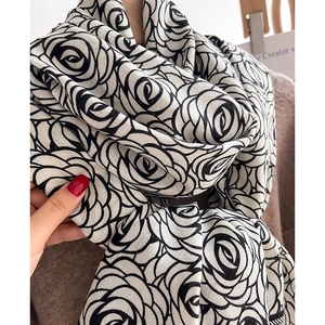 Close-up of elegant black rose pattern on soft knit winter shawl for women