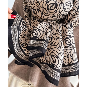 Detail of soft cashmere beige shawl with black rose floral pattern and geometric stripes