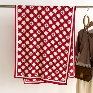 Detail of red and cream polka dot scarf with camellia floral patterns and satin texture