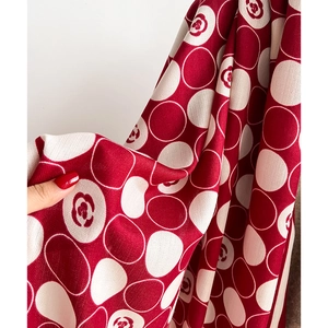 Close-up of red and white polka dot scarf featuring vintage rose patterns and twill weave