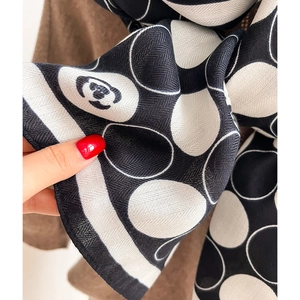 Macro shot of herringbone weave texture and panda logo on polka dot scarf