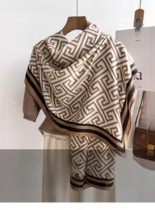 Detail of a large shawl with khaki geometric Greek key pattern and soft wool texture
