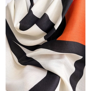 Macro shot of geometric contrast color scarf featuring black white and orange silk twill texture