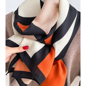Chic herringbone knit scarf with geometric color block design in orange and black