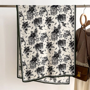 Detailed drape of vintage building print scarf with dark green hem on a metal rack