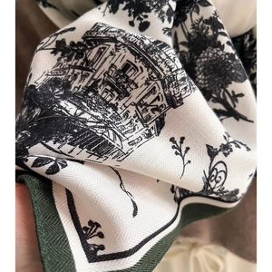 Detail of elegant Toile de Jouy floral print scarf with green stitched edges