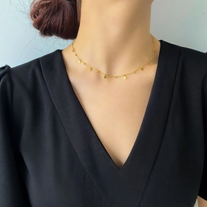 Detail of 18k gold plated disc and bead necklace on a minimalist choker chain