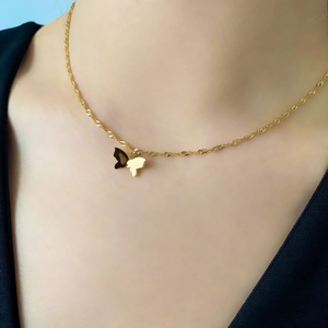 Gros plan du pendentif papillon doré avec effet 3D sur une chaîne à mailles torsadées