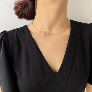 Detailed close-up of a minimalist 18k gold plated choker necklace with round disc charms
