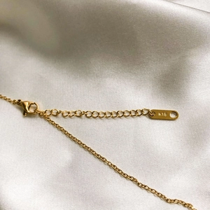 Macro shot of gold-plated butterfly necklace with K18 stamp and adjustable clasp
