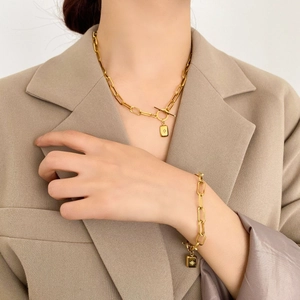 Parure de bijoux dorée avec chaîne trombone, fermoir à bascule et pendentif étoile carrée