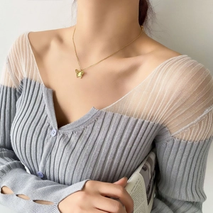 Close-up of gold-plated hollow butterfly pendant necklace worn by a female model