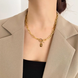 Détail du collier à gros maillons dorés avec fermoir toggle et pendentif étoile