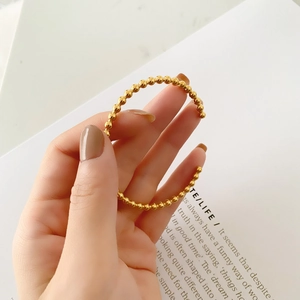 Polished rose gold beaded cuff bracelet shown on wrist with a minimalist open design