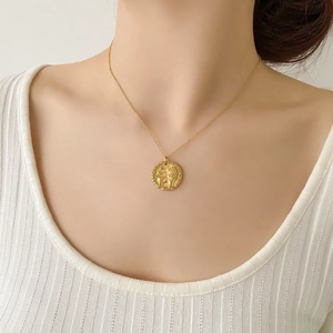 Dettaglio della collana con ciondolo a leone d'oro indossata da una modella