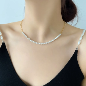 Elegant gold chain necklace with white artificial pearls shown on a female model