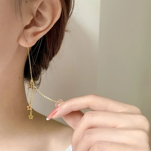 Long gold titanium tassel earrings with hollow pentagram stars on a female model