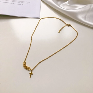 Gros plan du collier croix en argent S925 doré avec un détail de chaîne cubaine épissé