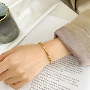 Detail of rose gold beaded bracelet with minimalist round beads on female wrist