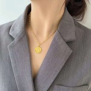 Dettaglio della collana a moneta d'oro con pendente a rilievo su catena a fune