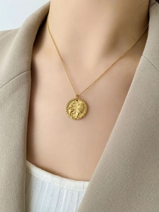Collana a moneta d'oro con rilievo di leone indossata da modella in stile urban chic