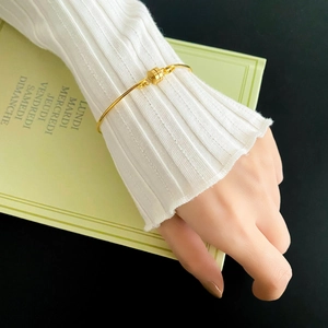 Minimalist gold bangle with a cylindrical magnetic clasp and high-polished finish