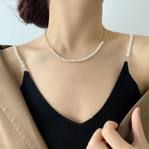 Detailed view of asymmetric necklace featuring half pearls and 18K gold-plated chain links