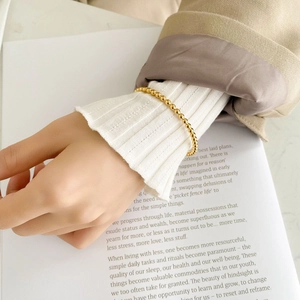Detail of beaded rose gold plated stainless steel bangle bracelet on a female wrist