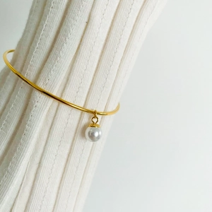 Elegant minimalist gold-plated bangle featuring a single lustrous white pearl pendant charm