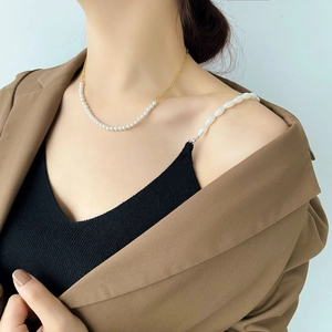 Detailed view of artificial pearl necklace with golden paperclip chain stitching for women