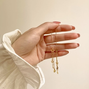 Detail of gold titanium steel tassel earrings featuring multiple pentagram star pendants