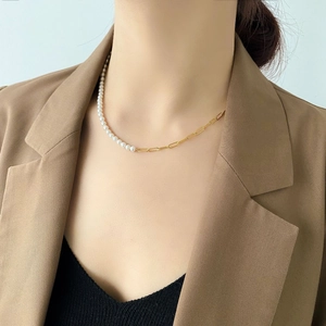 Detail of half pearl half gold chain necklace worn with a blazer for modern elegant style
