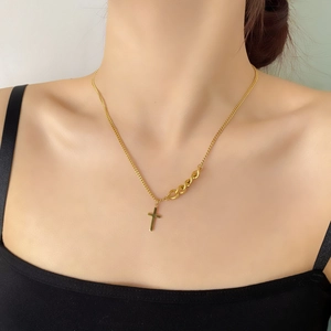 Détail du collier pendentif croix dorée avec un design moderne de chaîne mixte