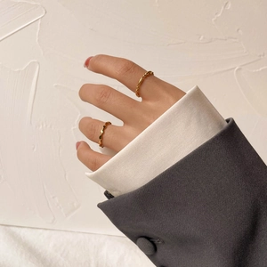 Bagues dorées à perles et carrées de style français portées par un mannequin