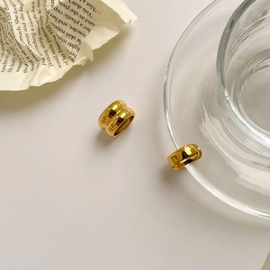 Détail des boucles d'oreilles créoles à double épaisseur en acier titane doré poli
