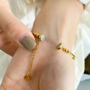 Macro shot of gold magnetic bracelet with grey pearl inlay and adjustable link chain